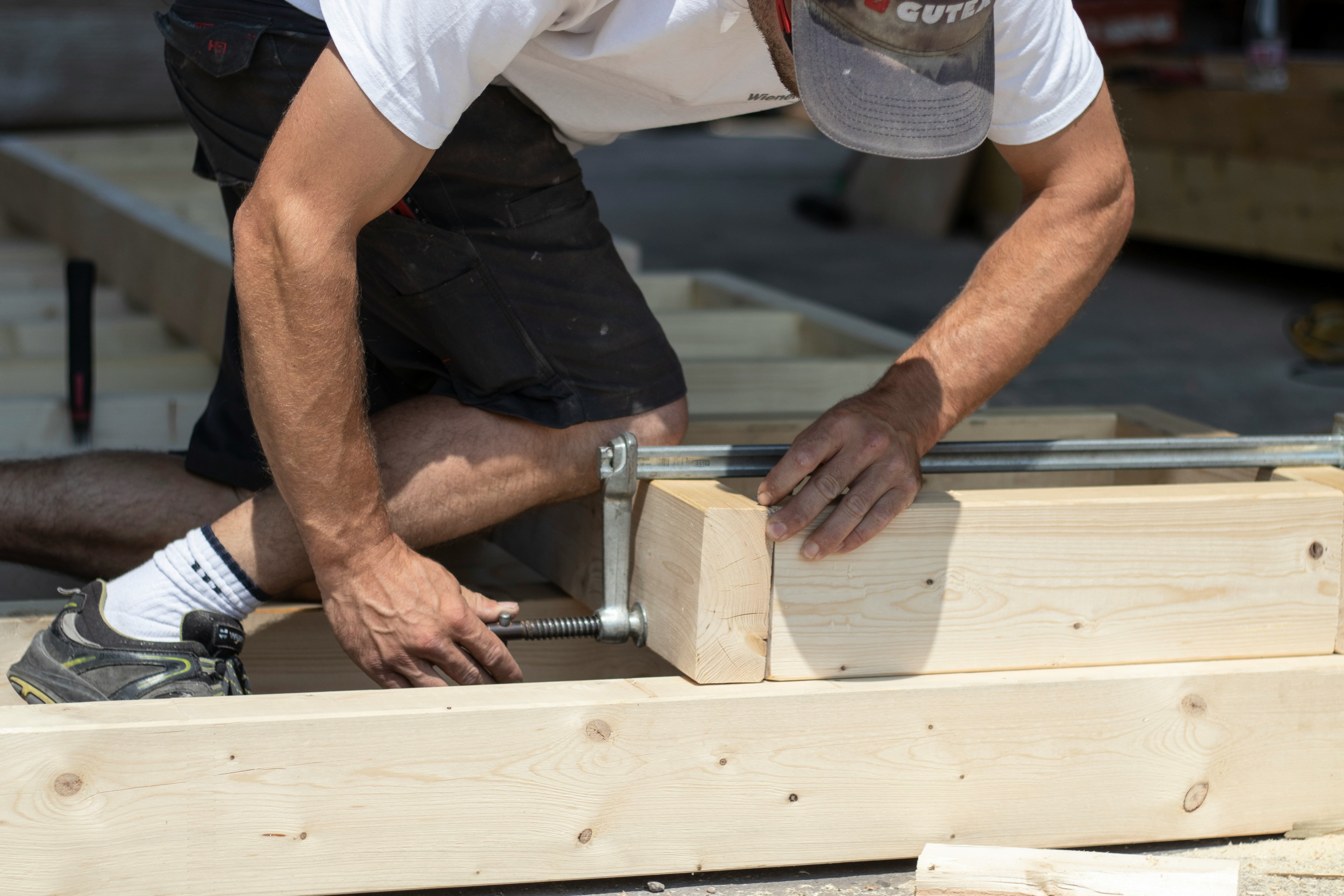 Ein Mann der ein Stück Holz ausmisst 